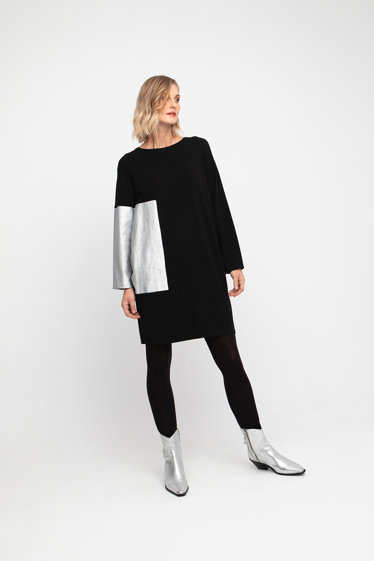 Model wearing a black knit dress with silver metallic detail & pockets